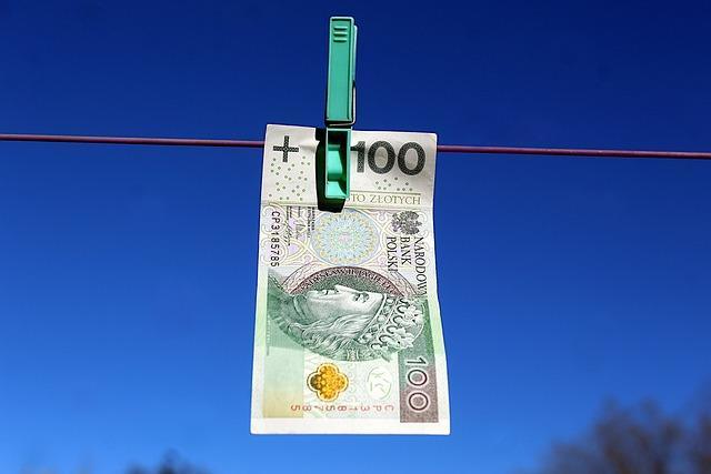banknot 100zł powieszony na lince na pranie klamerką